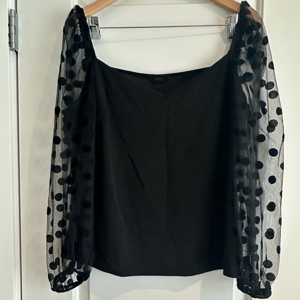 Black top with sheer polka dot sleeves. Size XL